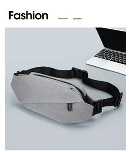 Detail of grey oxford fabric waist bag with adjustable strap next to a laptop