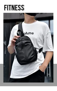 Détail du sac bandoulière noir imperméable sur un mannequin masculin avec style fitness
