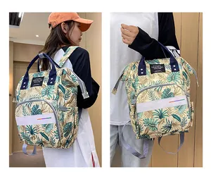 Detail of floral diaper bag featuring reinforced dual handles and tropical leaf patterns