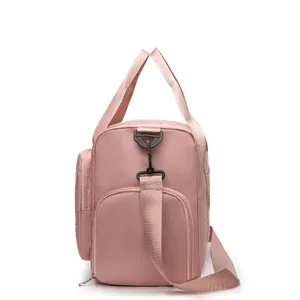 Pink travel bag detail featuring reinforced handles and a detachable shoulder strap