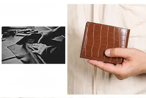 Detail of dark brown crocodile embossed leather wallet with fine stitching and polished finish