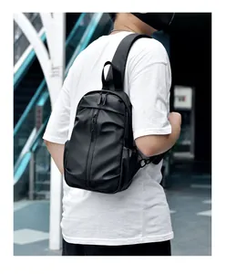 Détail d'un sac à bandoulière noir étanche avec fermeture éclair verticale sur un modèle