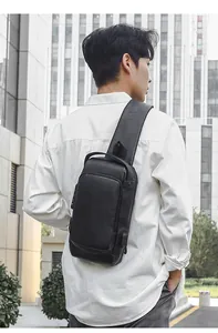 Detail of waterproof black sling bag showing anti-theft lock and USB charging port