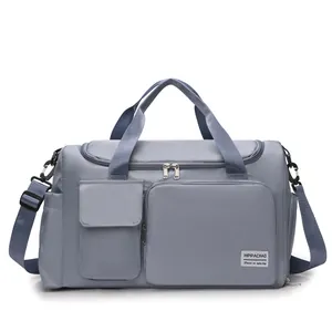 Detail of blue nylon travel bag with dual front pockets and adjustable shoulder strap