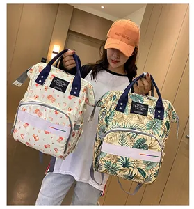 Detail of waterproof diaper bags showing cartoon bear and tropical leaf patterns with zips