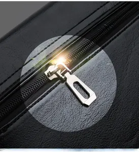 Close-up of premium black pebble leather texture with a shiny silver metal zipper detail