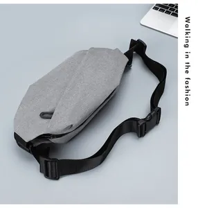 Close-up of grey Oxford fabric crossbody bag with textured finish and black strap