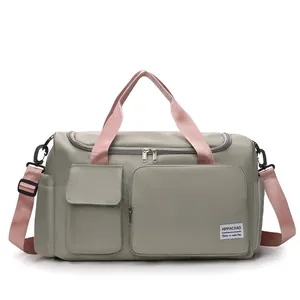 Macro view of gray nylon travel bag with pink straps and multi-pocket front detail