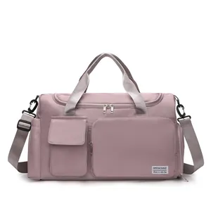Macro view of dusty pink nylon travel bag featuring reinforced grey handles and metal zippers