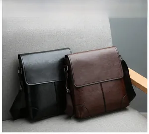 Waterproof PU leather vertical crossbody bags in black and brown on a grey fabric chair