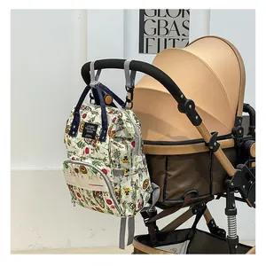 Floral diaper backpack with stroller straps hanging on a handlebar for easy travel