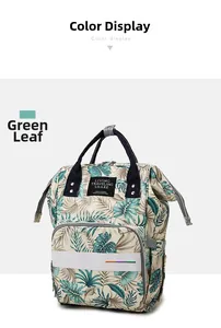 Detail of multi-functional diaper bag featuring green tropical leaf pattern and top handle