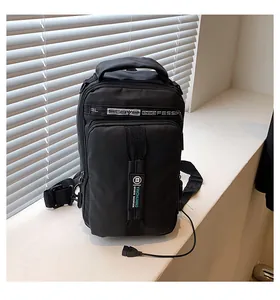 Détail du port de chargement USB externe et du tissu en nylon de ce sac de poitrine noir