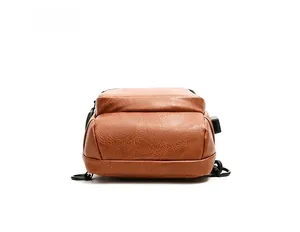 Detail view of the brown leather chest bag base showing USB port and metal hardware