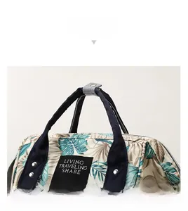 Detail of tropical leaf print bag showing reinforced navy handles and ergonomic design