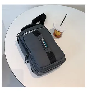 Vue de dessus d'un sac de poitrine en nylon gris foncé avec port USB sur table blanche
