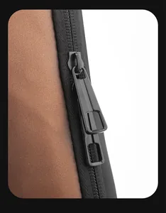 Close-up of double black zippers and brown matte leather texture on a trendy crossbody bag