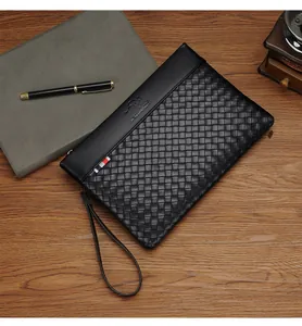 Macro detail of the black woven texture and embossed logo on this business clutch bag