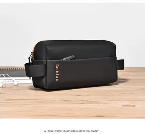 Nahaufnahme der schwarzen Nylontasche mit orangefarbenem Fashion-Text und Reißverschluss
