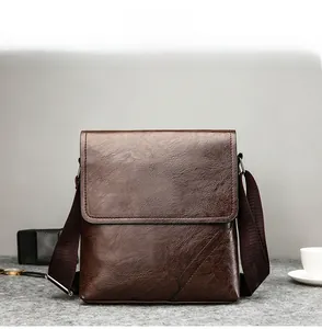 Macro shot of dark brown PU leather texture and shoulder strap on men's crossbody bag