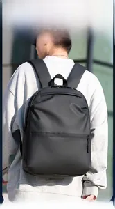 Outdoor shot showing the side view and strap detail of this minimalist black laptop backpack