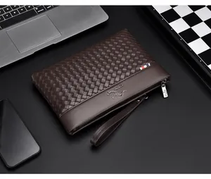 Close-up of brown woven leather clutch with silver logo and tricolor ribbon detail