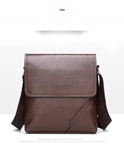 Detail view of brown men's shoulder bag featuring textured faux leather and flap cover