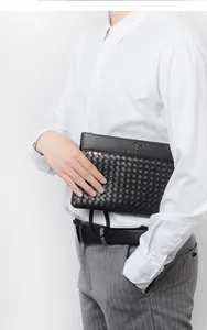 Detail of men's black business clutch featuring woven texture and premium leather finish