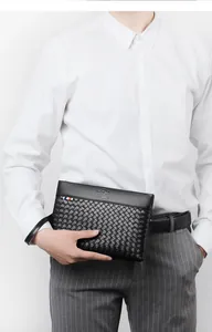 Detail of woven texture and kangaroo logo on black leather men's clutch bag