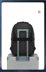 Detail of the luggage strap on a black business backpack attached to a silver suitcase