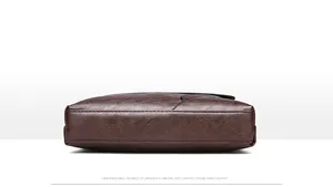 Detailed bottom view of large brown leather business bag showing neat stitching and capacity