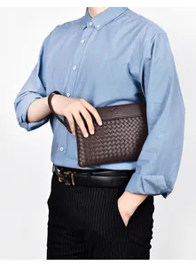 Detailed view of dark brown woven texture clutch bag and black leather belt with golden H-buckle