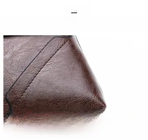 Detailed macro view of dark brown PU leather texture and fine stitching on the men shoulder bag