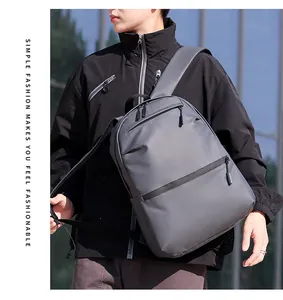 Detail view of the sleek waterproof synthetic fabric and dual zipper pockets on gray backpack
