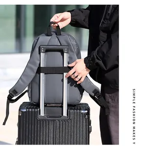 Detail showing grey laptop backpack securely attached to a luggage handle via back strap