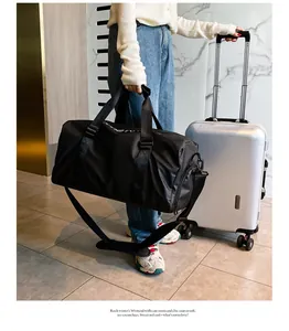 Nahaufnahme der schwarzen Reisetasche mit Nassfach und schickem weißen Textdetail