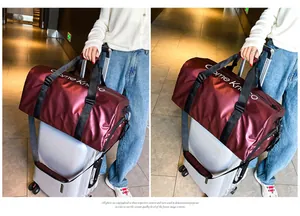 Burgunderrote Reisetasche mit Nass-Trocken-Trennung am Koffergriff befestigt