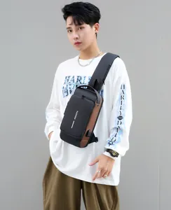 Detail showing the USB charging port and mixed material texture of the men's chest bag