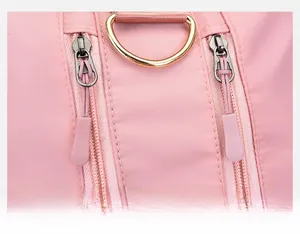 Detail of pink travel bag showing double smooth zippers and golden metal D-ring hook