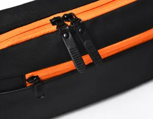 Detailaufnahme der glatten orangen Reißverschlüsse mit mattschwarzen Schiebern am Slingbag