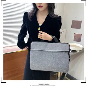 Borsa porta PC in tessuto grigio con manici e tracolla indossata da una modella