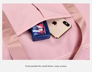 Detailed view of pink waterproof travel bag with reinforced straps and functional front pocket
