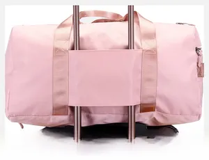 Pink travel bag detail showing the convenient luggage sleeve for suitcase attachment