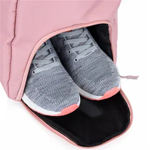 Detailed view of the pink gym bag showing a separate shoe compartment with grey sneakers