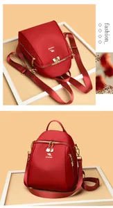 Dettagli dello zaino in nylon rosso con cerniere dorate e logo a canguro