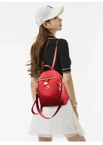 Dettaglio dello zaino in nylon rosso impermeabile con logo a canguro dorato e finiture