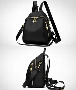 Dettaglio dello zaino in nylon nero con cerniere dorate e logo metallico a canguro