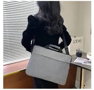 Borsa porta PC grigia impermeabile con tracolla regolabile mostrata in un ambiente business
