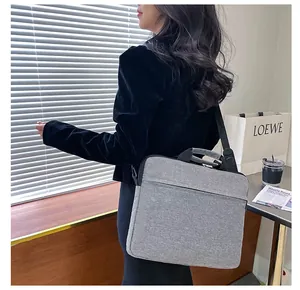 Dettaglio della borsa porta PC in tessuto grigio con manico rinforzato e tracolla