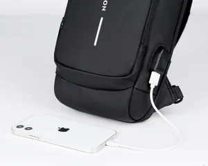 Detail showing the external USB charging port on a black waterproof crossbody sling bag
